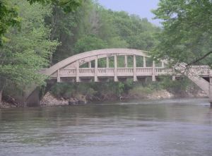 A bridge over a river with trees along the side