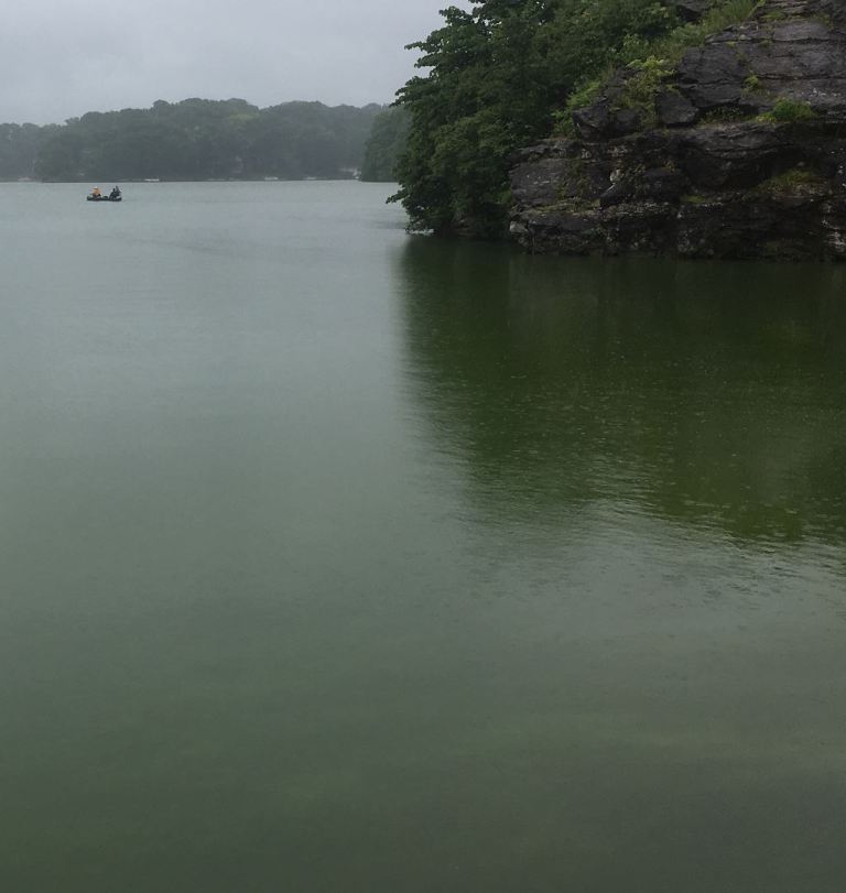 Dark green lake with a tall rock face