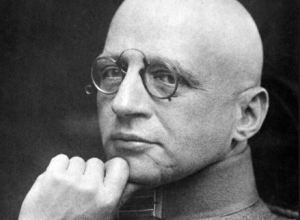 Fritz Haber presses his hand to his chin as if in thought, looking at the camera with a solemn expression