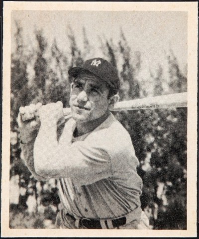 Yogi Berra stands with a baseball bat 